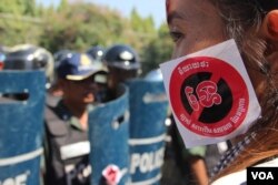 រូបឯកសារ៖ កម្លាំងប៉ូលិសត្រូវបានដាក់ពង្រាយ ខណៈមានការតវ៉ានៅមុខព្រឹទ្ធសភាប្រឆាំងនឹងការអនុម័តលើសេចក្តីព្រាងច្បាប់ស្តីសមាគមនិងអង្គការមិនមែនរដ្ឋាភិបាល កាលពីថ្ងៃទី២៤ ខែកក្កដា ឆ្នាំ២០១៥។ (ប៉ាង ចំណាន/VOA)