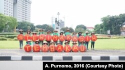Komunitas Kretek members in Jakarta hold up letters that say "Thank you tobacco."