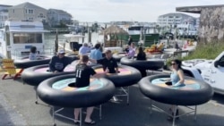 In this image made from Saturday, May 16, 2020, video provided by Revolution Event Design & Production, "bumper tables," created by the company and designed to allow people to practice social distancing.