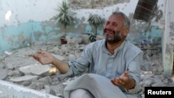 A man cries in front of houses destroyed during a recent Syrian Air Force air strike in Azaz, about 47 kilometers north of Aleppo, Syria, August 15, 2012.