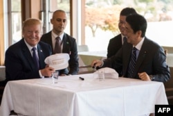 US President Donald Trump speaks with Japan's Prime Minister Shinzo Abe during a luncheon at the Kasumigaseki Country Club Gold Course in Tokyo, Nov. 5, 2017.