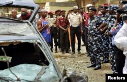 An eye witness of the bomb blast gives his account to the Kano commissioner of the police during the police chief's assessment of the situation in Sabon Gari, Kano, May 19, 2014.