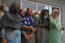 Relatives of slain school principal Supinder Kour mourn during his funeral procession in Srinagar, Indian-administered Kashmir, Oct. 8, 2021.