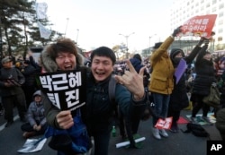 FILE - Protesters celebrate after hearing the news of President Park Geun-hye's impeachment in front of the National Assembly in Seoul, South Korea, Dec. 9, 2016.