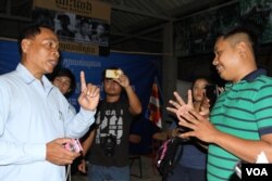 លោក ឆឺយ ឧត្តមរស្មី កូនប្រុសរបស់លោក ឈុត វុទ្ធី ចរចារជាមួយអាជ្ញាធរខ័ណ្ឌសែន សុខបន្ទាប់ពីមានការហាមឃាត់មិនឲ្យចាក់បញ្ចាំងខ្សែភាពយន្តឯកសារ «ខ្ញុំជាឈុត វុទ្ធី» កាលពីថ្ងៃអង្គារទី២៦ ខែ​មេសា ឆ្នាំ​២០១៦ នៅផ្ទះសាមគ្គីរាជធានីភ្នំពេញ។ (ឡេង ឡែន/VOA)