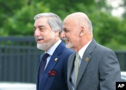 FILE - Afghanistan's President Ashraf Ghani, right, and Chief Executive Abdullah Abdullah arrive for sessions of a NATO Summit, in Warsaw, Poland, July 9, 2016.