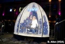 Fans at Super Bowl Live in Minneapolis, Minnesota, pose inside of a live-sized snow globe.