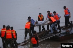 Rescue workers carry a body from the sunken ship in the Jianli section of Yangtze River, Hubei province, China, June 2, 2015.