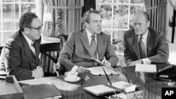 FILE - Then-vice presidential nominee Gerald R. Ford (R) listens as President Richard Nixon, accompanied by Secretary of State Henry Kissinger, speaks in the Oval Office of the White House in Washington, Oct. 13, 1973.