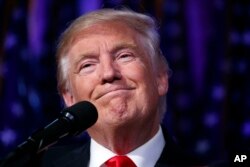 FILE - President-elect Donald Trump smiles as he arrives to speak at an election night rally, Nov. 9, 2016.