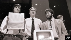 In this April 24, 1984, file photo, Steve Jobs, left, chairman of Apple Computers, John Sculley, center, president and CEO, and Steve Wozniak, co-founder of Apple, unveil the new Apple II computer in San Francisco. (AP Photo/Sal Veder)
