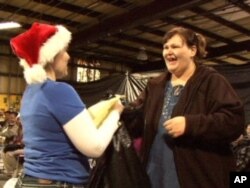 After submitting their holiday requests, families pick up presents and necessities from the Angel Tree warehouse. Tia McCoy asked for basic necessities for her son and daughter.