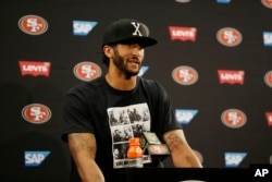 San Francisco 49ers quarterback Colin Kaepernick answers questions at a news conference after an NFL preseason football game against the Green Bay Packers.