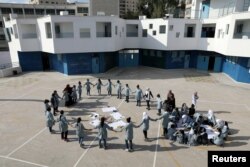 FILE - Palestinian children take part in an activity at a school run by the U.N. Relief and Works Agency in the Shuafat refugee camp in East Jerusalem Oct. 10, 2018.