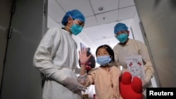 A girl, who was previously infected with the H7N9 bird flu virus, waves as she is being transferred to a public ward from the ICU at Ditan hospital in Beijing, Apr. 15, 2013.
