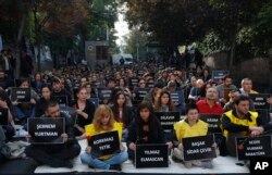 The students of Ankara University hold the placards with the names of those killed in Saturday's deadly explosions during a sit-in protest in Ankara, Turkey, Oct. 13, 2015.