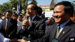 FILE PHOTO - Opposition leader of Cambodia National Rescue Party Sam Rainsy, center, delivers a speech next to his Deputy President Kem Sokha, right, during a gathering to mark Human Rights Day, in front of National Assembly, in Phnom Penh, Cambodia.