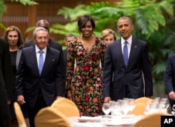 President Barack Obama, right, and first lady Michelle arrive for a state dinner with Cuba's President Raul Castro, left, at the Palace of the Revolution in Havana, March 21, 2016.