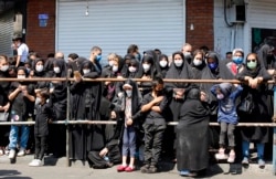 IRAN -- Iranian and Iraqi Shiite Muslims, wearing protective face masks, watch a reenactment of the events of the tenth day of the month of Muharram, which marks the peak of Ashura, in the Iranian capital Tehran on August 30, 2020.