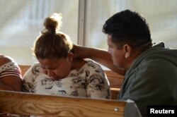 FILE - Central American migrants wait to enter the U.S., asking for refuge and to be reunited with the children they were separated from when crossing into the United States illegally last year, at the border crossing in Mexicali-Calexico, Mexico, March 2, 2019.