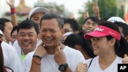 FILE - Lt. Gen. Hun Manet, center, of the Royal Cambodian Armed Forces (RCAF) and the first son of Cambodian Prime Minister Hun Sen, smiles before the start of the international half-marathon in front of Royal Palace in Phnom Penh, Cambodia, Sunday, June 