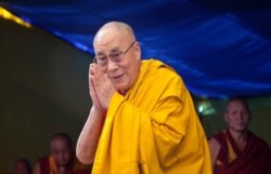 Pemimpin spiritual Tibet, Dalai Lama, menyapa umat saat ia tiba untuk memberikan ceramah agama di Sekolah Desa Anak-anak Tibet di Dharmsala, India. (AP)