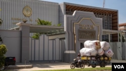 រូបឯកសារ៖ បុរសម្នាក់ដឹកឥវ៉ាន់កាត់ធនាគារជាតិនៃកម្ពុជា ក្នុងរាជធានីភ្នំពេញ ប្រទេសកម្ពុជាកាលពីថ្ងៃទី០៣ ខែមិថុនា ឆ្នាំ២០២០។ (ទុំ ម្លិះ/VOA)