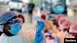 FILE - A health worker fills a syringe with Ebola vaccine before injecting it to a patient, in Goma, Democratic Republic of Congo, Aug. 5, 2019.