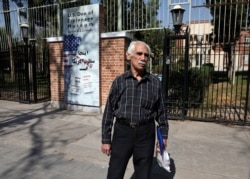 FILE - Hossein Kouhi, who was one of the workers who frequently protested at the U.S. Embassy, speaks with an Associated Press journalist in front of the former U.S. Embassy in Tehran, Iran, Oct. 15, 2019.