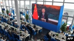 采访博鳌论坛的记者们在媒体厅观看屏幕上显示的中国国家主席习近平在开幕式上讲话。（2021年4月20日）