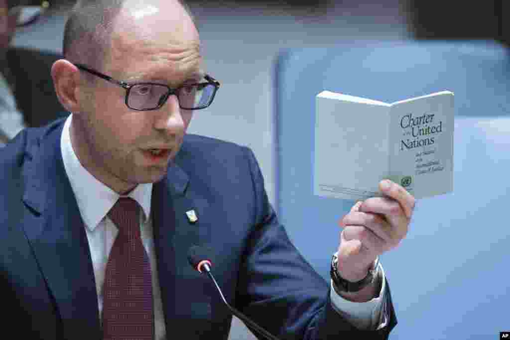 Ukraina Bosh vaziri Arseniy Yatsenyuk BMT xartiyasi bitilgan kitobcha bilan, 13-mart, 2014