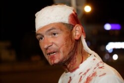 A man wounded during clashes with police speaks to people during a mass protest following presidential elections in Minsk, Belarus, Aug. 10, 2020.