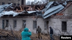 FILE - Residents walk at the site of a Russian missile strike, amid Russia's attack on Ukraine, in Dnipro, Ukraine, Nov. 21, 2024.