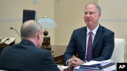 ທ່ານ ຄີຣີລ ດມີທຣຽບ, ຜູ້ບໍລິຫານກອງທຶນດ້ານຄວາມໝັ້ນ ຄົງແຫ່ງຊາດຂອງຣັດເຊຍ, ຂວາ, ກໍາລັງຟັງການໂອ້ລົມຂອງ ທ່ານ ວະລາດີເມຍ ປູຕິນ, ລະຫວ່າງການພົບປະຢູ່ທີ່ເຮືອນພັກ Novo-Ogaryovo ນອກນະຄອນຫຼວງມົສກູ, ຣັດເຊຍ, ວັນທີ 18 ມິຖຸນາ 2018. (Alexei Druzhinin, Sputnik, Kremlin Pool Photo via AP)