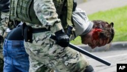 Riot police officers detain a protester during a rally protesting the official presidential election results in Minsk, Belarus, Sept. 13, 2020.