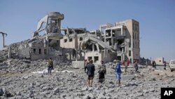 Warga memeriksa lokasi pasca serangan Saudi atas sebuah penjara kelompok Houthi di provinsi Dhamar, Yaman hari Minggu (1/9). 