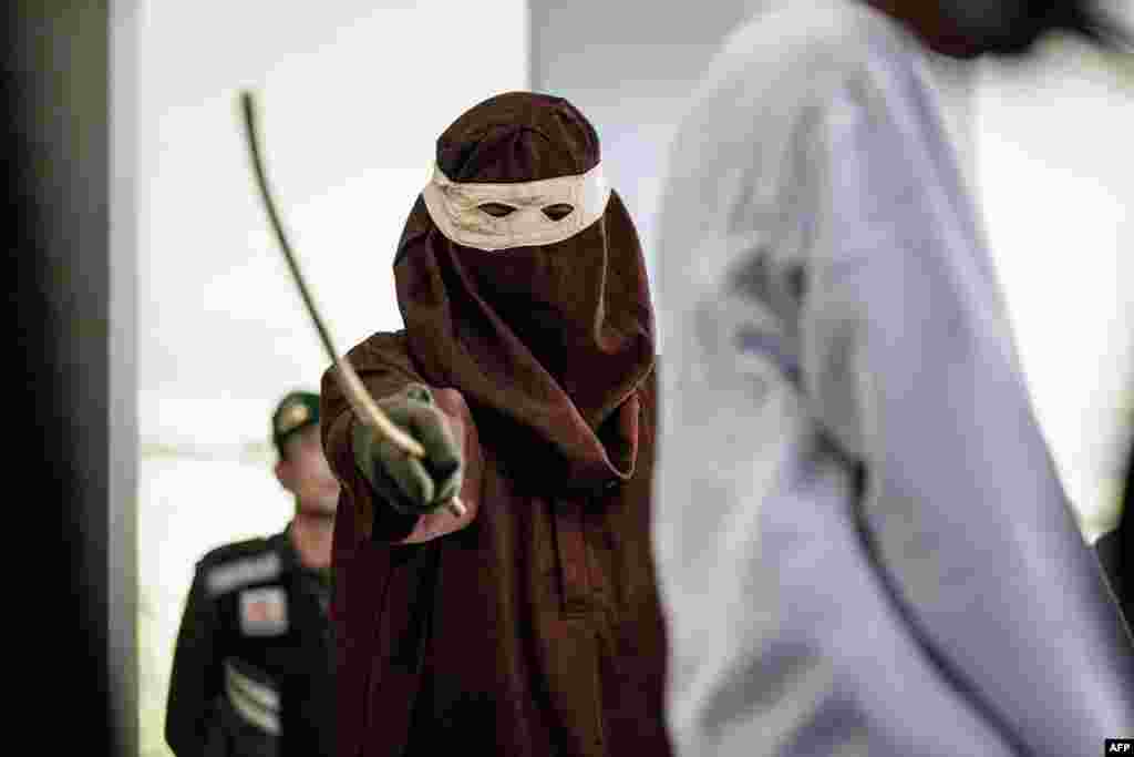 Seorang pria, yang dinyatakan bersalah atas hubungan seksual sesama jenis dengan pria lain, berdasarkan hukum syariah Islam yang ketat, dihukum cambuk di depan umum di Banda Aceh. (AFP)&nbsp;