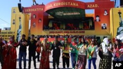 Kurdish people dance during the Nowruz celebrations in southeastern Turkish city of Diyarbakir, March 21, 2014. 