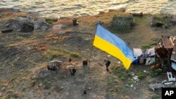 រូបឯកសារ៖ ទាហាន​អ៊ុយក្រែន​ដោតទង់ជាតិ​អ៊ុយក្រែន​នៅ​កោះ Snake ក្នុង​តំបន់​សមុទ្រខ្មៅ កាលពី​ថ្ងៃទី៧ ខែកក្កដា ឆ្នាំ២០២២។ 