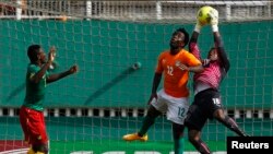 Fabrice Ondoa, gardien du Cameroun, à droite, subtilise une balle de la tête de Wilfried Bony de la Côte d'Ivoire lors du match de qualification pour la Coupe d'Afrique des Nations au stade Felix Houphouet Boigny à Abidjan, 19 novembre 2014. 