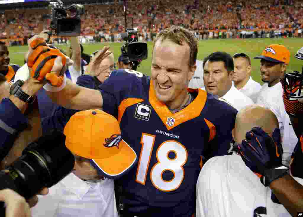 Peyton Manning celebrates his 509th career touchdown pass with teammates in Denver, Oct. 19, 2014.