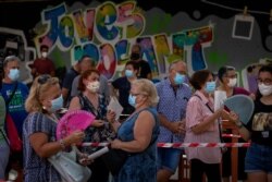 People wearing face masks wait their turn to be called for a PCR test for the COVID-19 at Vilafranca del Penedes in the Barcelona province, Spain, August 10, 2020.