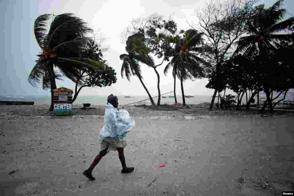 Seorang perempuan melindungi diri dari hujan saat Badai Matthew mendekat di Les Cayes, Haiti (3/10).&nbsp;(Reuters/Andres Martinez Casares)