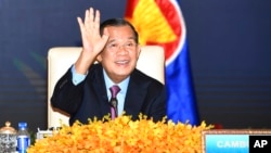 រូបឯកសារ៖ លោក​នាយក​រដ្ឋមន្ត្រី ហ៊ុន សែន លើកដៃ​នៅពេល​លោក​ចូលរួម​កិច្ចប្រជុំ​តាម​ប្រព័ន្ធ​អ៊ីនធឺណិត​នៃ​កិច្ចប្រជុំ​កំពូល​ពិសេស​អាស៊ាន-ចិន នៅ​វិមាន​សន្តិភាព រាជធានី​ភ្នំពេញ ប្រទេស​កម្ពុជា កាលពី​ថ្ងៃទី២២ ខែវិច្ឆិកា ឆ្នាំ២០២១។