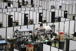 In this April 5, 2020 photo, soldiers work at a nursing station in the intensive care section of a military field at the CenturyLink Field Event Center in Seattle.