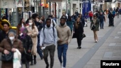 FILE - People walk along a shopping street as shops reopened after lockdown was loosened during the coronavirus (COVID-19) pandemic in Vienna, Austria, May 3, 2021.
