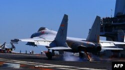 중국이 동중국해에서 실탄 실전훈련을 실시한 가운데, 중국 항모전단 랴오닝호 갑판 위에서 J15 전투기가 이륙하고 있다. 