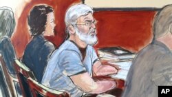 In this courtroom drawing, Mustafa Kamel Mustafa , center, is flanked by his defense team, attorney Julie Howe, left, and Joshua Dratel, right, in New York, April 14, 2014. 