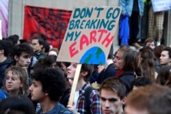FILE - Youths demonstrate for climate change during a "Fridays for Future" school strike, in front of the Ecology Ministry in Paris, France, Feb. 15, 2019.