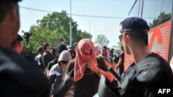 17일 크로아티아와 세르비아 국경 지역 난민들이 크로아티아 경찰의 감독을 받으며 버스에 올라타고 있다.